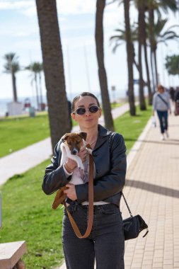 Küçük köpeği olan bir kadın yürüyüşe çıkmış.