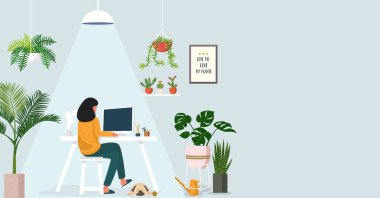 Evde dizüstü bilgisayarda çalışan kadın iç mekan bitkileriyle süslenmiş.