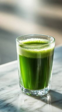 Mermer yüzey üzerinde kristal yeşil sebze suyu, yumuşak altın sabah ışığı, zarif bulanık kaplıca arka plan, temiz kopya alanı ile rafine edilmiş düzen..