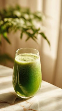 Mermer yüzey üzerinde kristal yeşil sebze suyu, yumuşak altın sabah ışığı, zarif bulanık kaplıca arka plan, temiz kopya alanı ile rafine edilmiş düzen..