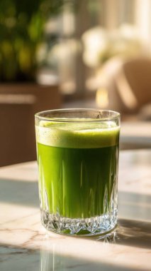 Mermer yüzey üzerinde kristal yeşil sebze suyu, yumuşak altın sabah ışığı, zarif bulanık kaplıca arka plan, temiz kopya alanı ile rafine edilmiş düzen..