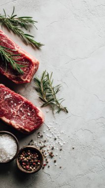 Top view flat lay of raw steak, rosemary, salt, and pepper on rustic background with copy space, soft natural light, realistic texture, cooking preparation concept, clean professional style for website or print.