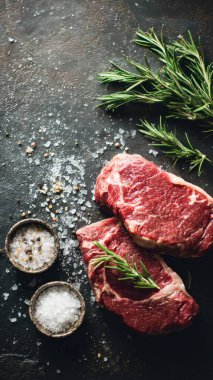 Top view flat lay of raw steak, rosemary, salt, and pepper on rustic background with copy space, soft natural light, realistic texture, cooking preparation concept, clean professional style for website or print.