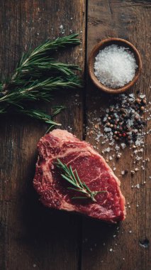 Top view flat lay of raw steak, rosemary, salt, and pepper on rustic background with copy space, soft natural light, realistic texture, cooking preparation concept, clean professional style for website or print.