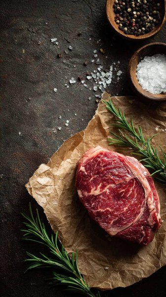 Top view flat lay of raw steak, rosemary, salt, and pepper on rustic background with copy space, soft natural light, realistic texture, cooking preparation concept, clean professional style for website or print.