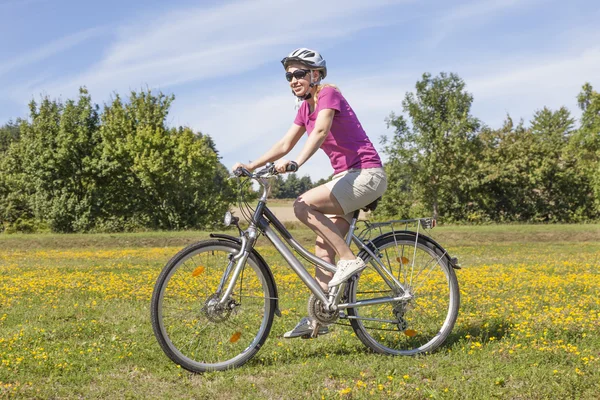 Giovane donna con una bicicletta — Foto Stock