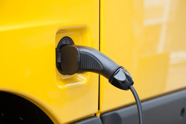 Πρίζα και το καλώδιο στο ένα κίτρινο ηλεκτρικό αυτοκίνητο — Φωτογραφία Αρχείου