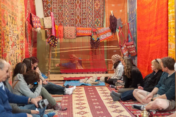 Touristes regardant femme marocaine tisser tapis traditionnel. Maroc, Afrique — Photo