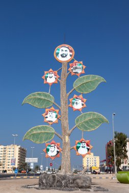 UMM AL QUWAIN, UAE - DEC 17: Tree with portraits of the sheikhs in Umm Al Quwain. December 17, 2014 in the emirate Umm Al Quwain, United Arab Emirates clipart