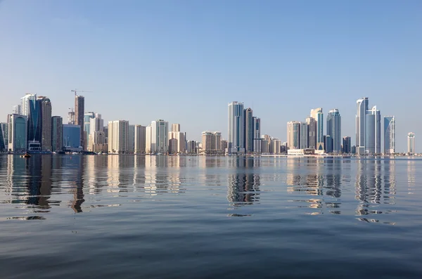 Sharjah stadssilhuetten återspeglar i bäcken. Sharjah, Förenade Arabemiraten — Stockfoto