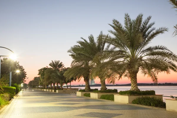 Strandpromenaden i Abu Dhabi belysta i skymningen, Förenade Arabemiraten — Stockfoto