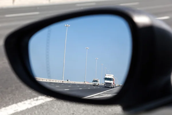 Camiones en carretera en el espejo retrovisor — Foto de Stock