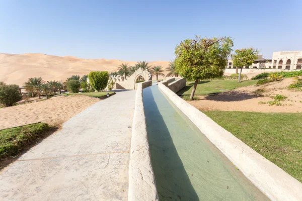 Bewässerungskanal in einem Wüstenresort. Emirat abu dhabi, vereinigte arabische Emirate — Stockfoto