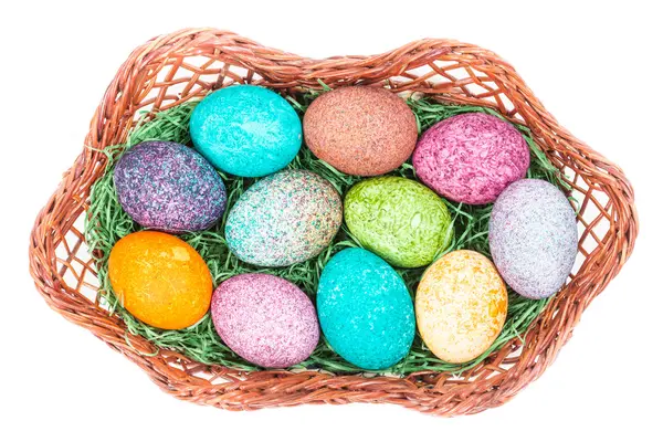 Uova di Pasqua in un cesto isolato su bianco — Foto Stock