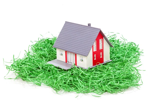 Modelo casa na grama verde isolado no fundo branco — Fotografia de Stock