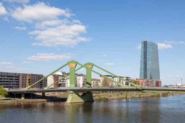 ФРАНКФУРТ-МАЙН, ГЕРМАНИЯ - 18 АПР: Флоссерский мост через реку Майн и новый Европейский центральный банк (ЕЦБ) во Франкфурте. 18 апреля 2015 года во Франкфурте-Майне, Германия — стоковое фото