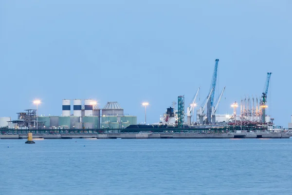 Refinería iluminada al atardecer — Foto de Stock