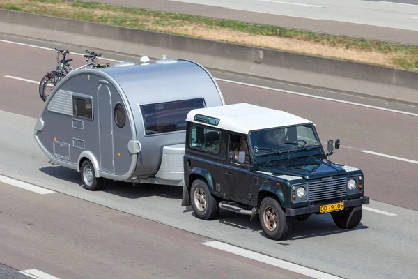 Land Rover Defender with a small Caravan — стокове фото