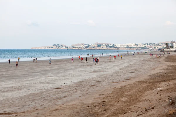 Omanska män spelar fotboll på stranden i Muscat — Stockfoto