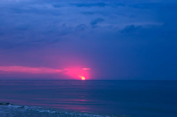 Colorful sunrise with sun on cloudy sea