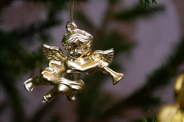 Christmas card with golden angel playing on a mandolin on a Christmas tree. Place for text. Christmas card with blured background