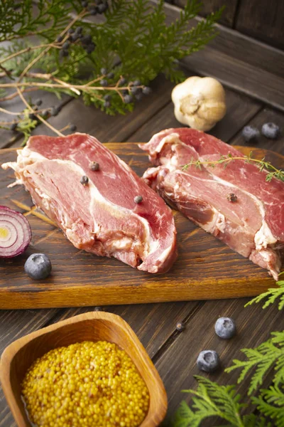 Viande Fraîche Sanglier Sur Planche Pour Couper Avec Des Bleuets Image En Vente