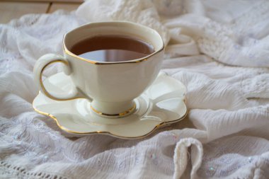 Beyaz bir arka planda çay dolu antika porselen çay fincanı. Yakın plan.