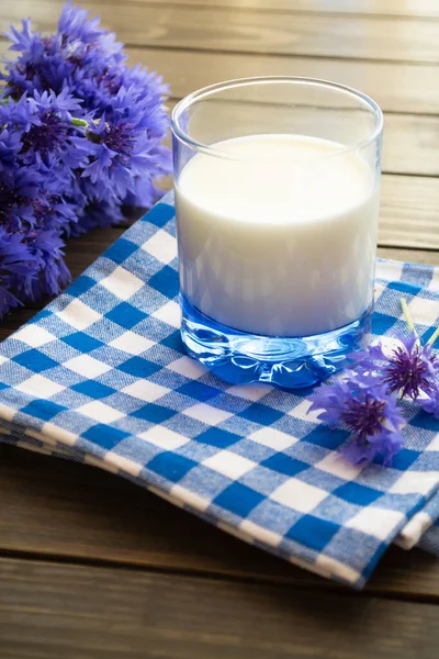 Pot de lait et de bleuets sur une vieille table en bois marron — Photo