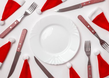 Geleneksel Noel masası seti boş beyaz tabak, keten peçete, şenlikli çatal bıçak takımı. Yeni yıl geçmişi ve tatil konsepti. Düz konum, kopyalama alanı olan üst görünüm