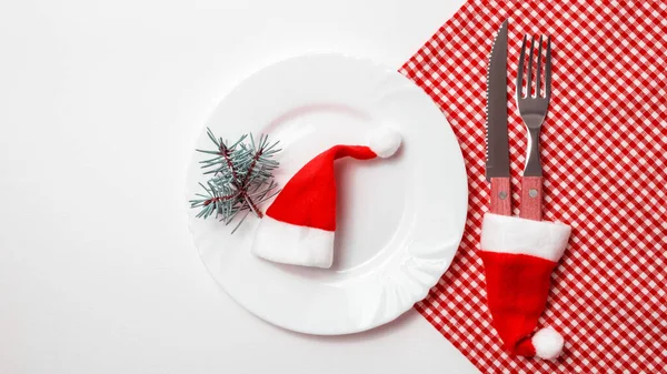 Geleneksel Noel masası seti boş beyaz tabak, keten peçete, şenlikli çatal bıçak takımı. Yeni yıl geçmişi ve tatil konsepti. Düz konum, kopyalama alanı olan üst görünüm