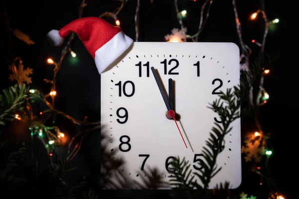 用黑色背景锁住新年冷杉的枝条 二手在机械钟的圆圈中移动 并在午夜和圣诞节前夕显示12点钟方向 假日概念 — 图库照片