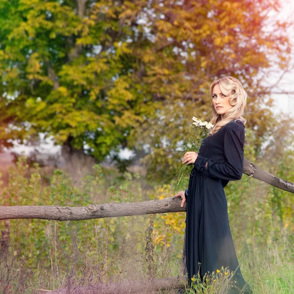 Bella donna bionda in abito nero in giorno d'estate, all'aperto — Foto Stock