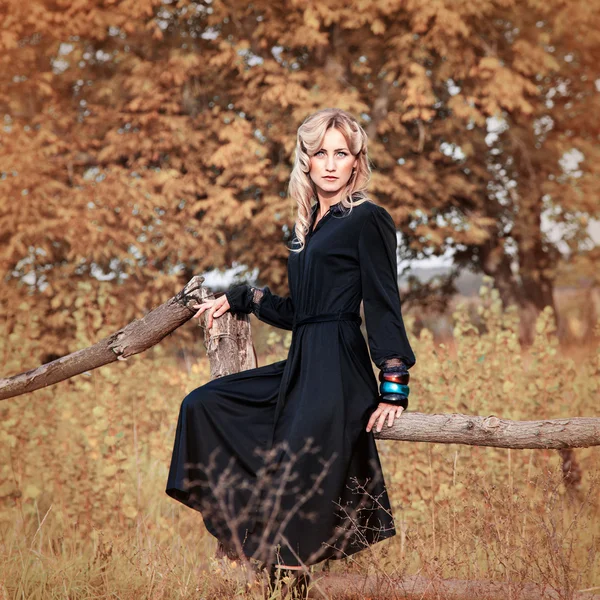 Belle femme blonde en robe noire le jour d'été, en plein air — Photo