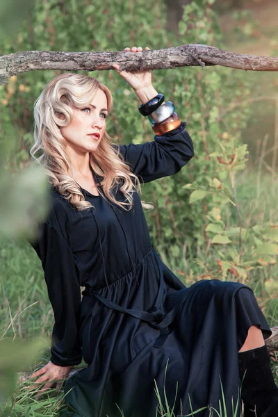 美丽的金发女人，穿着夏季的一天，室外的黑色连衣裙 — 图库照片