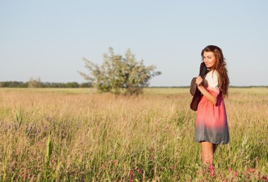 Çayır üzerinde şapka duran sıcak yaz gününde romantik genç kadın