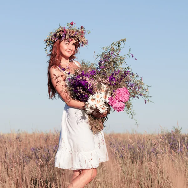 Porträt einer jungen schönen Frau mit Blumenstrauß, die einen Kranz trägt — Stockfoto