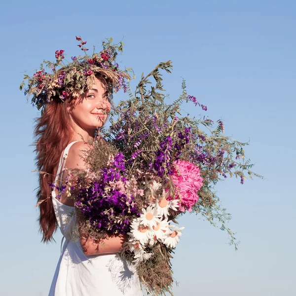 Porträt einer jungen schönen Frau mit Blumenstrauß, die einen Kranz trägt — Stockfoto