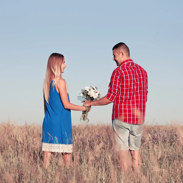 Love story. Beautiful young couple walking in meadow, outdoor