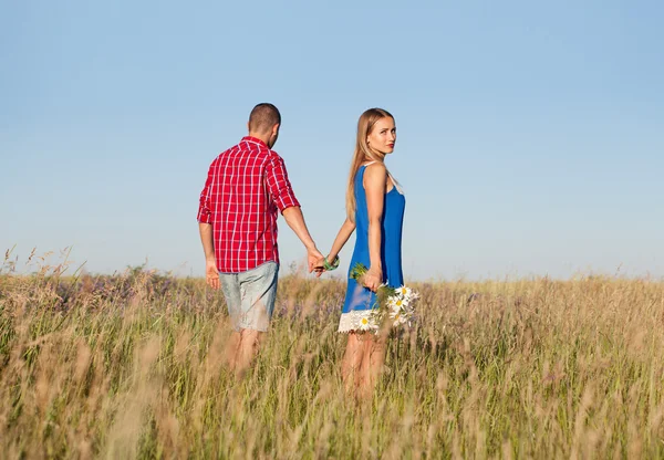 Storia d'amore. Bella giovane coppia passeggiando nel prato, all'aperto. P — Foto Stock