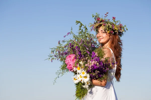 Portret van jonge mooie vrouw met boeket, dragen een krans Stockfoto