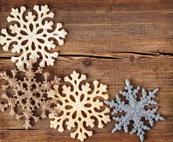 Christmas background. Snowflakes border on grunge wooden board. — Stock Photo, Image