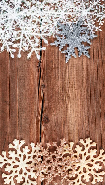 Fundo de Natal. Flocos de neve na borda da tábua de madeira grunge . — Fotografia de Stock