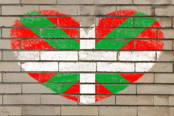 Баскский флаг в форме сердца на кирпичной стене — стоковое фото