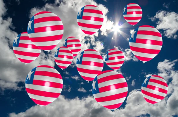 Many balloons with liberia flag on sky — Stock Photo, Image