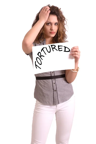 Nepříjemná žena drží papír s textem mučen — Stock fotografie