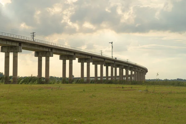 タイ中央部で最大の貯水池であるパサックジョラシードダムでの鉄道橋の上のタイのローカル列車輸送と旅行のコンセプトで曇った空を持つロッブリ県 — ストック写真