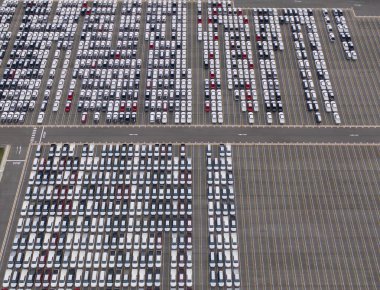 Satılık yeni arabaların park alanlarının hava manzarası stok sırası, dağıtım envanteri ithalat ve ihracat ticareti dünya çapında, otomobil ve otomobil endüstrisi lojistik küresel ulaşım dağıtımı