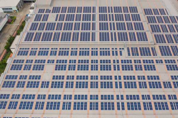 Aerial view of solar panels or solar cells on the roof in farm. Power plant with factory industry, renewable energy source in Thailand. Eco technology for electric power.