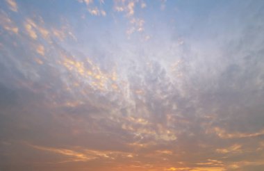 Soyut doğa geçmişi. Alacakaranlık vakti, turuncu renkli günbatımı bulutlarıyla dramatik mavi gökyüzü.
