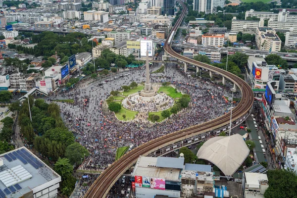 Aerial top view of flash mobs protesters demonstration rally on street road against government, crowd of people at Victory Monument in Bangkok City, Thailand in public for democracy.